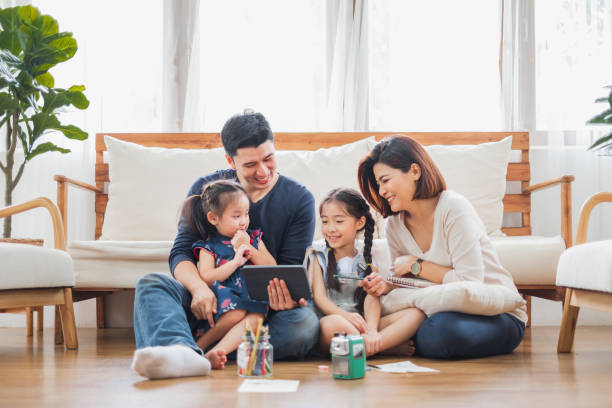 lentor-hills-residences-book-appointment-singapore Happy Asian family using tablet, laptop for playing game watching movies, relaxing at home for lifestyle concept
